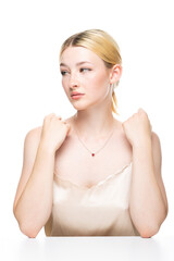 A young blonde girl with freckles in a golden top. Beauty portrait of a woman on a white background...