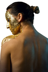 Girl with a mask on her face made of gold leaf. Gloomy studio portrait of a brunette on an abstract...