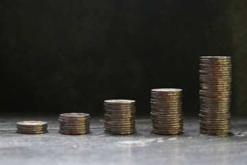 Stacks of coins on black background, business and finance concept.