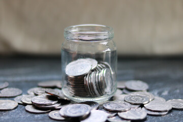 Coins in a glass jar on the table. Saving money concept