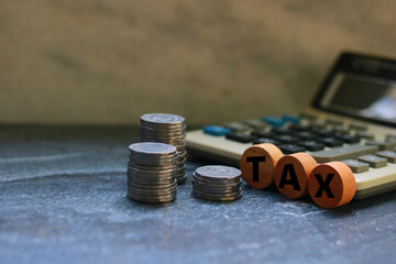 Tax concept with coins and calculator on the table. Selective focus.