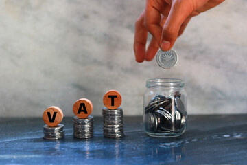 Coins stacked on each other forming the word VAT. The concept of increasing income.