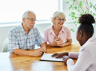 Happy senior old family couple clients make financial insurance estate business deal contract...