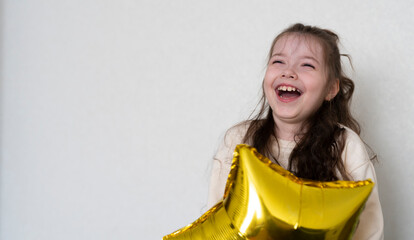8 year old girl laughing with a balloon in her hands. High quality photo