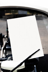 Blank white paper on car windshield