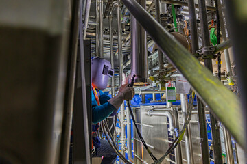 Welding arc argon worker male repaired pipeline stainless chemicals is welding sparks industrial