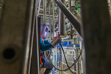 Welding arc argon worker male repaired pipeline stainless chemicals is welding sparks industrial