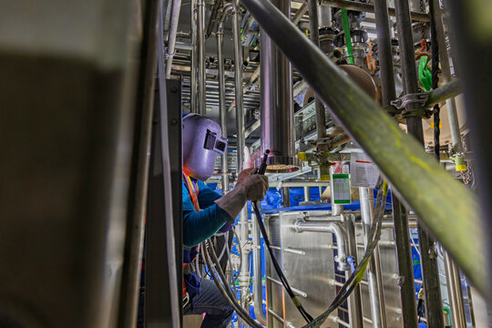 Welding arc argon worker male repaired pipeline stainless chemicals is welding sparks industrial