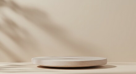 Elegant beige podium display on a minimal background with soft, natural leaf shadows for product presentation.