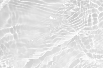 White water with ripples on the surface. Defocus blurred transparent white colored clear calm water surface texture with splashes and bubbles. Water waves with shining pattern texture background.