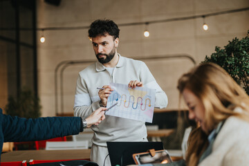 A group of colleagues shares ideas and reviews data presentations in a casual meeting environment,...