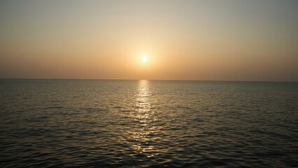 A serene sunset over calm waters, creating a tranquil atmosphere and soft reflections in the gentle waves.