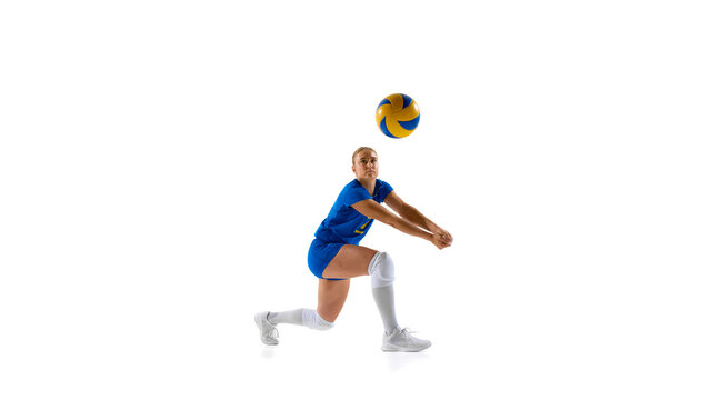 Female volleyball player diving to hit ball on white background. Concept of full-speed movement, agility showcase, sports apparel branding, and active youth lifestyle promotion.