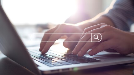 Close-up of hands typing on a laptop with a search bar graphic overlay computer keyboard