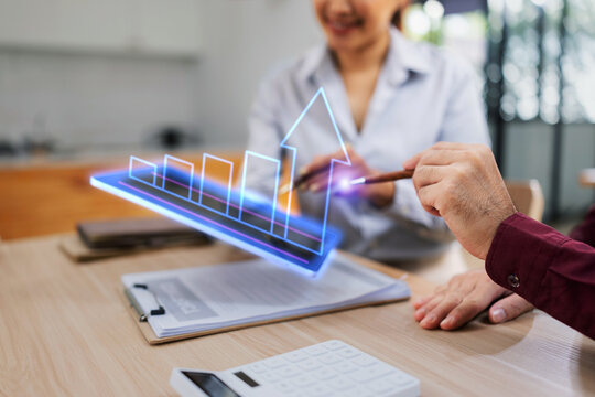 Businessman and woman holding digital tablet with futuristic interface for analytics data dashboard.