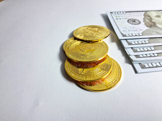 Gold bitcoins and banknotes on white background. Business concept.