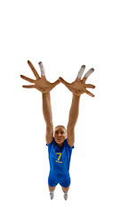 Fototapeta premium Full-body female volleyball player jumping high with arms raised to block, focused and determined. Concept of summer games, defensive skills, coaching materials, and sports education.