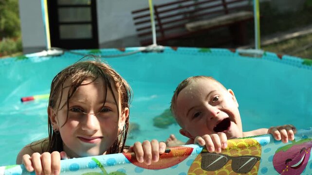 Children in pool. Two children in the pool are laughing, enjoying and mocking the camera.