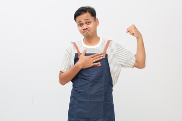 Asian young man wearing apron over white background strong person showing arm muscle, confident and...