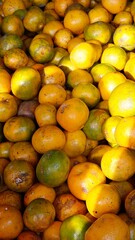 Bright oranges displayed in open sunlight at a traditional market stall, symbolizing freshness and natural produce.
