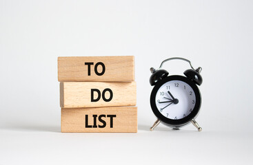 To Do List symbol. Concept words To Do List on wooden blocks. Beautiful white background with alarm...
