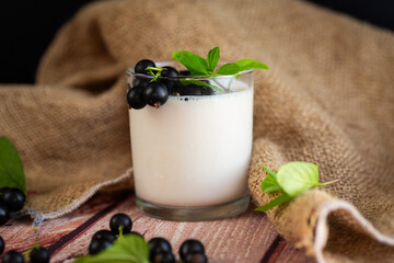 Natural yogurt with blackcurrant on a wooden