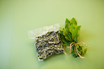 Frozen sorrel in a bag and a bunch of fresh sorrel