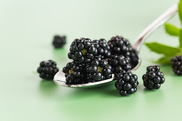 Ripe juicy blackberries on a green background