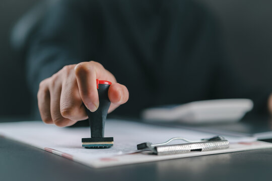 Sign Approved Stamp On Document to permit and certify for work document and visa At Desk