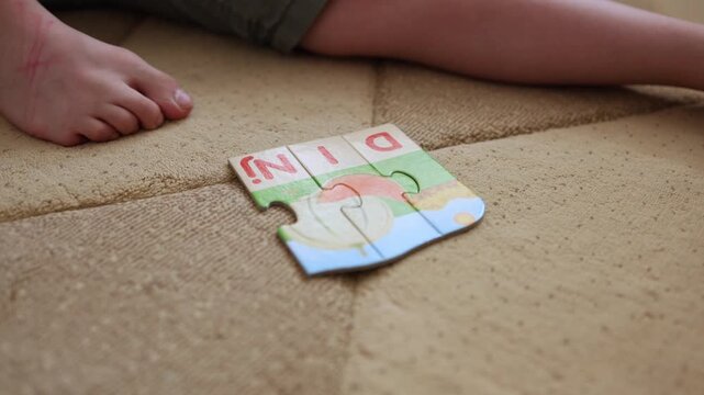 Children's hands are putting together puzzles with letters. Detail. Close up shot. 