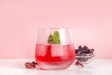 Hibiscus Water or lemonade, summer infused flower drink with iced hibiscus tea, lime slices and mint, refreshing and cooling, healthy hydration pink natural cocktail