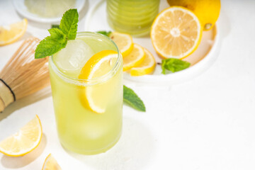Iced Matcha Lemonade cocktail. Green iced matcha tea infused drink with lemon slices and fresh mint...