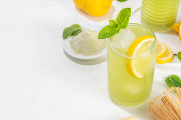 Iced Matcha Lemonade cocktail. Green iced matcha tea infused drink with lemon slices and fresh mint...