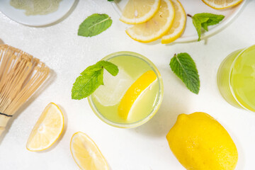Iced Matcha Lemonade cocktail. Green iced matcha tea infused drink with lemon slices and fresh mint...