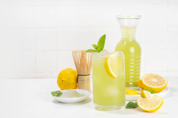 Iced Matcha Lemonade cocktail. Green iced matcha tea infused drink with lemon slices and fresh mint...