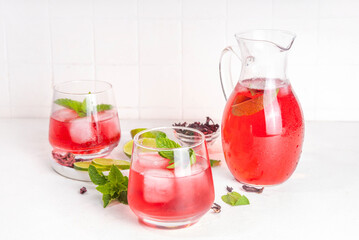 Hibiscus Water or lemonade, summer infused flower drink with iced hibiscus tea, lime slices and mint, refreshing and cooling, healthy hydration pink natural cocktail