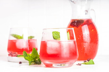 Hibiscus Water or lemonade, summer infused flower drink with iced hibiscus tea, lime slices and mint, refreshing and cooling, healthy hydration pink natural cocktail