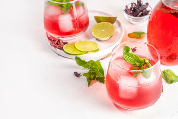 Hibiscus Water or lemonade, summer infused flower drink with iced hibiscus tea, lime slices and mint, refreshing and cooling, healthy hydration pink natural cocktail