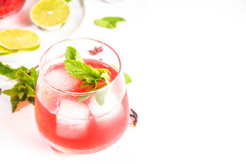 Hibiscus Water or lemonade, summer infused flower drink with iced hibiscus tea, lime slices and mint, refreshing and cooling, healthy hydration pink natural cocktail