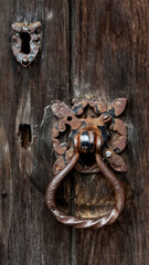Close view of a beautifully crafted antique door handle and worn keyhole set against a rustic...