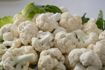Fresh and raw cauliflower on the white plate.  The cauliflower  -  vegetable is cut into pieces on...