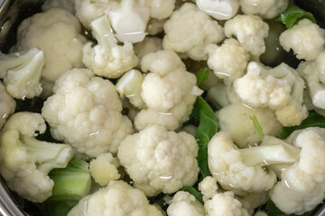 Fresh cauliflower is boiled in a saucepan with water. The vegetable is divided into florets and...