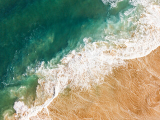 Aerial View of Ocean Waves Hitting Sandy Shore. Aerial drone view. natural background