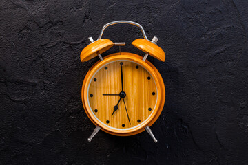 Vintage wooden alarm clock with bells at seven o'clock. Morning routine. In time concept