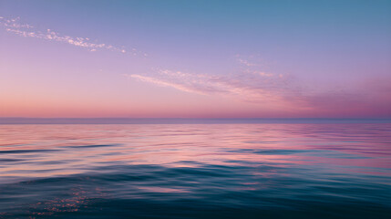 Obraz premium **Serene pastel sky blending into a calm ocean, reflecting soft sunset hues
