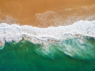 Aerial View of Ocean Waves Hitting Sandy Shore. Aerial drone view. natural background