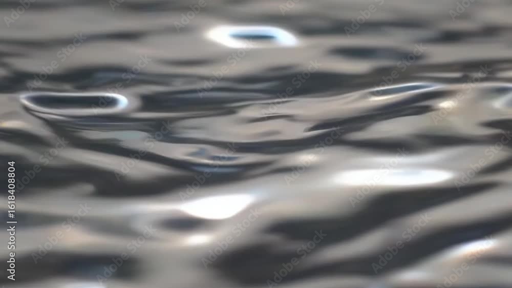 Poster close-up view of shimmering water with soft, rippling surface. the water reflects light creating a s