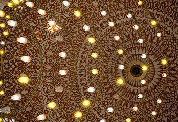 Ornate mosque ceiling glows with symmetrical Islamic lights
