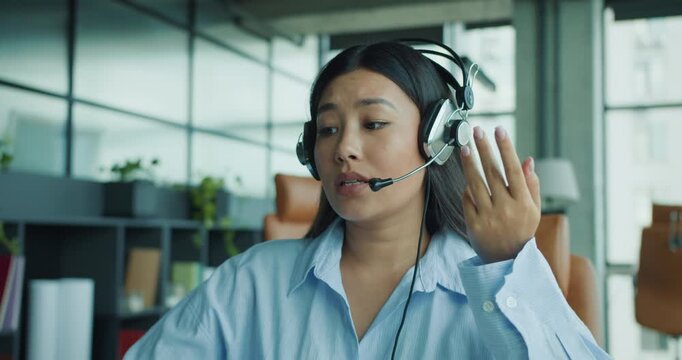 A highly focused woman wearing a headset actively engages with clients in a modern and sleek office space