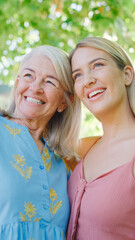 Multi-Generation Family With Senior Mother And Adult Daughter Laughing In Garden